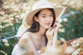 Beautiful girl in vintage dress and hat standing near colorful flowers Royalty Free Stock Photo