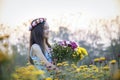 Beautiful girl in vintage dress and hat standing near colorful flowers Royalty Free Stock Photo