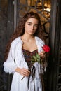 Beautiful girl in a vintage style dress with a red rose in her hands Royalty Free Stock Photo