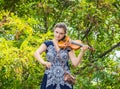 Beautiful girl violinist professionally plays a musical instrument in a city park Royalty Free Stock Photo