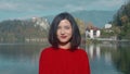 Beautiful girl walking near the lake and enjoying the magnificent view of the Alph mountains and sunny weather. Smiling