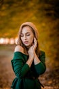 Beautiful girl walking outdoors in autumn. Smiling girl collects yellow leaves in autumn. Young woman enjoying autumn weather Royalty Free Stock Photo