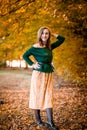 Beautiful girl walking outdoors in autumn. Smiling girl collects yellow leaves in autumn. Young woman enjoying autumn weather Royalty Free Stock Photo