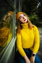 Beautiful girl walking outdoors in autumn. Smiling girl collects yellow leaves in autumn. Young woman enjoying autumn weather. Royalty Free Stock Photo