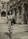 Beautiful girl walking in a post-war Italian city in the 1940s