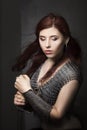 Beautiful girl warrior in chain mail with a sword in his hands. Medieval fantasy valkyrie with long hair posing on a dark backgrou Royalty Free Stock Photo