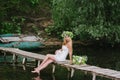 Beautiful girl wearing a crown sitting on a wooden bridge with a cat Royalty Free Stock Photo