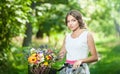 Beautiful girl wearing a nice white dress having fun in park with bicycle. Healthy outdoor lifestyle concept. Vintage scenery Royalty Free Stock Photo