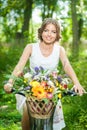 Beautiful girl wearing a nice white dress having fun in park with bicycle. Healthy outdoor lifestyle concept. Vintage scenery Royalty Free Stock Photo