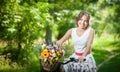 Beautiful girl wearing a nice white dress having fun in park with bicycle. Healthy outdoor lifestyle concept. Vintage scenery Royalty Free Stock Photo