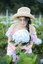 Beautiful girl with a field of hydrangea flowers