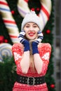 Beautiful girl wearing Santa Claus hat holding Christmas gift boxes in a festive outdoor atmosphere. Christmas and new year Royalty Free Stock Photo