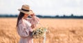 Beautiful girl in wheat field with ripe wheat in hands