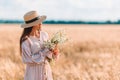 Beautiful girl in wheat field with ripe wheat in hands