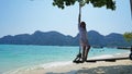 Beautiful girl in a white Cape and a black bathing suit on a swing. Swing on the beach. Royalty Free Stock Photo