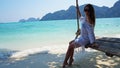 Beautiful girl in a white Cape and a black bathing suit on a swing. Swing on the beach. Royalty Free Stock Photo