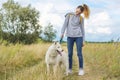 Beautiful girl with white dog, teenager walking with husky pet