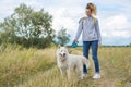 Beautiful girl with white dog, teenager walking with husky pet