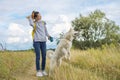 Beautiful girl with white dog, teenager walking with husky pet