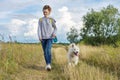 Beautiful girl with white dog, teenager walking with husky pet