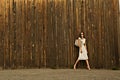 Beautiful girl in white dress against the wall