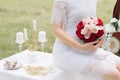 Beautiful girl in a white dress with a bouquet of flowers on nature in summer on a background of green leaves Royalty Free Stock Photo