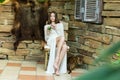 Beautiful girl in white dress posing with a glass of mojito in her hands