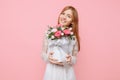 Beautiful girl in a white dress, stands with a bouquet of peonies, on a pink background. March 8 concept Royalty Free Stock Photo