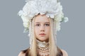 Beautiful girl in white flower hat and shiny pearls necklace posing on grey background Royalty Free Stock Photo