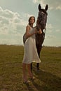 Beautiful girl in a white gown with horse Royalty Free Stock Photo