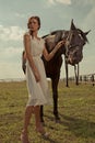 Beautiful girl in a white gown with horse Royalty Free Stock Photo