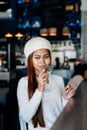 Beautiful girl in white outfit drinking Martini in a bar Royalty Free Stock Photo