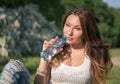 Beautiful girl in a white shirt is drinking water from a bottle Royalty Free Stock Photo