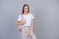 A beautiful girl in white t-shirt with backpack on her back, student smiles