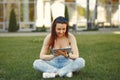 Girl sitting in a university campus use a tablet