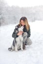 Beautiful girl in the winter wood plays with a dog Royalty Free Stock Photo