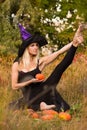 Beautiful girl in witch costume practicing yoga