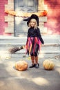little girl in witch costume celebrate Halloween outdoor and have fun
