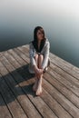 Beautiful girl on wooden pier near the water Royalty Free Stock Photo