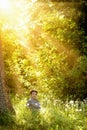 Beautiful girl in the woods. green background. sunbeams in the forest.