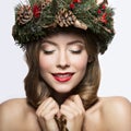 Beautiful girl with a wreath of Christmas tree branches and cones. New Year image. Beauty face. Royalty Free Stock Photo