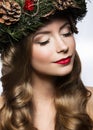 Beautiful girl with a wreath of Christmas tree branches and cones. New Year image. Beauty face. Royalty Free Stock Photo