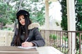 Beautiful girl writes in a notebook in a street restaurant Royalty Free Stock Photo