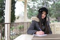 Beautiful girl writes in a notebook in a street restaurant Royalty Free Stock Photo