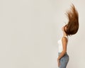 Beautiful girl 19 years old on light background in jeans and light T-shirt, long flying hair, closed eyes. Magic mood of youth, Royalty Free Stock Photo