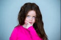 Beautiful girl 4-5 years old with long brown hair. The child is puzzled. In thought