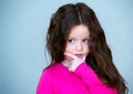 Beautiful girl 4-5 years old with long brown hair. The child is puzzled. In thought