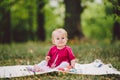 Beautiful Girl 1 Years Old Sitting On The Plaid In The Park. Child outdoor. Baby at picnic in forest. Portrait of a beautiful baby Royalty Free Stock Photo