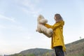 Beautiful girl in yellow cloak holds teddy bear walking through autumn nature. Young woman with soft toy outdoors Royalty Free Stock Photo