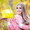 Beautiful girl with a yellow leather bag autumn day in nature Royalty Free Stock Photo